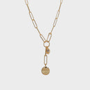 A gold paperclip chain necklace with a Y-shaped design, featuring a small bezel-set clear stone and a flat round disc pendant, shown on a light gray background.